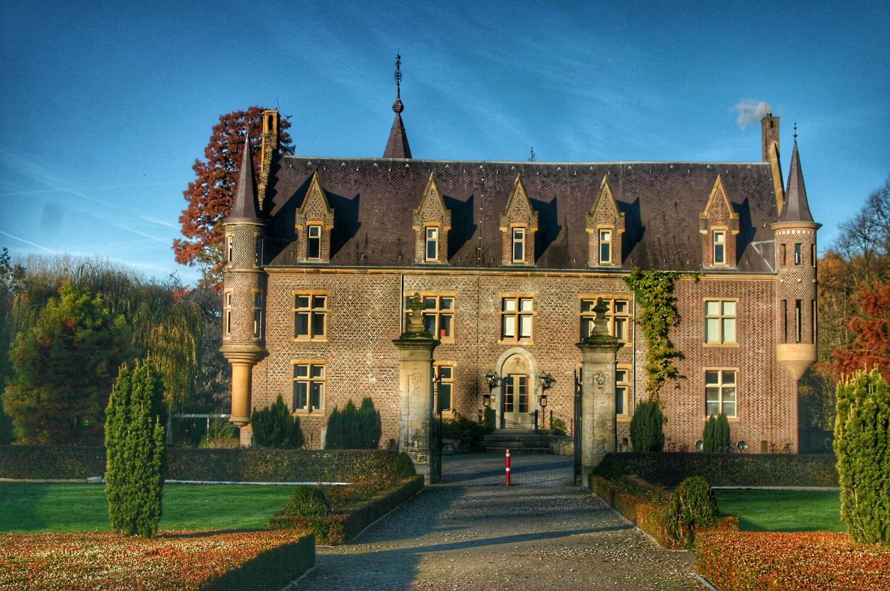 architecture, building exterior, built structure, blue, sky, history, sunlight, tree, clear sky, house, shadow, facade, day, old, residential structure, exterior, outdoors, low angle view, building, incidental people