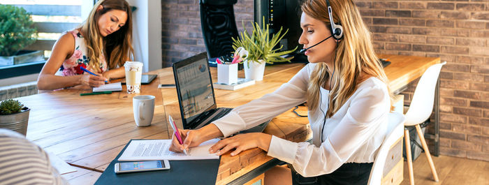 Young woman with headset in customer service of coworking