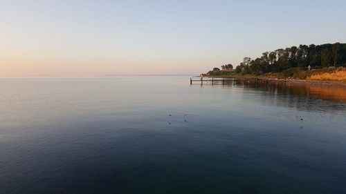 Scenic view of sea against clear sky during sunset