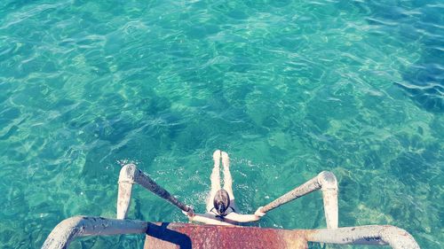 High angle view of woman sitting in sea