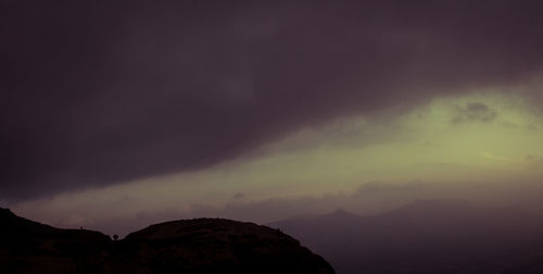 Scenic view of mountains against cloudy sky
