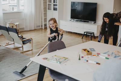 Portrait of smiling girl sitting on table at home