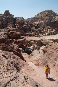High angle view of woman walking on mountain against clear sky