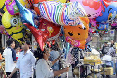 Woman selling multi colored balloons in market