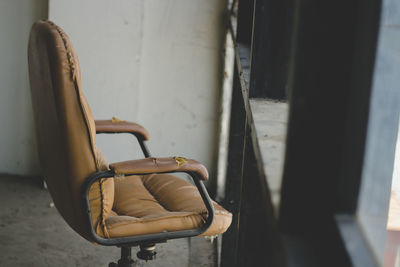 Empty chair against wall at home