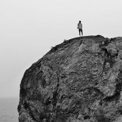 Man standing on cliff against clear sky