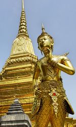 Low angle view of statue against temple against clear sky