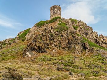 Low angle view of rock formation on mountain against sky