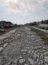 Surface level of cobblestone field against sky