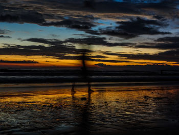 Scenic view of sea against dramatic sky during sunset