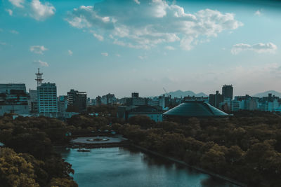 River amidst buildings in city against sky
