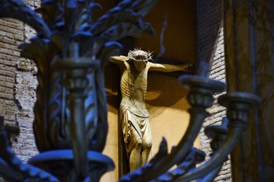 Statue of jesus christ in church viewed through candlestick holder