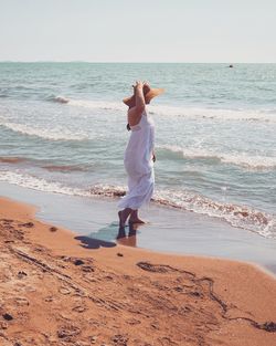 Full length of woman on beach against sky