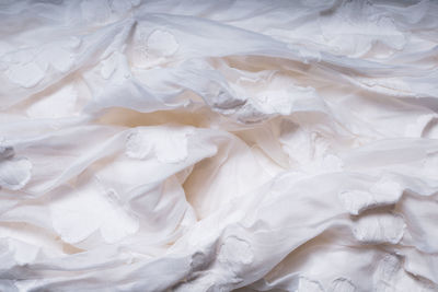 White texture with flowers. highly detailed closeup of crumpled textile.