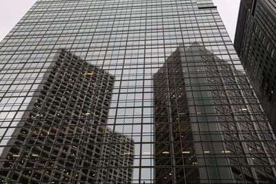 Low angle view of glass building against sky