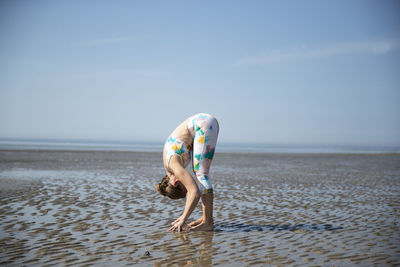 Full length of woman on beach against sky