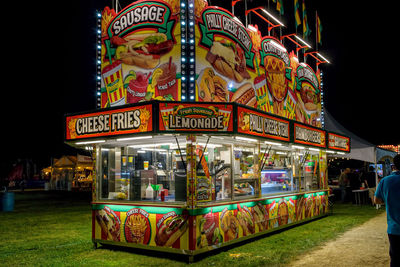 Illuminated ferris wheel at amusement park at night