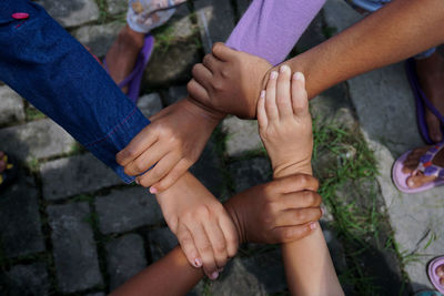 High angle view of people forming hand chain on footpath