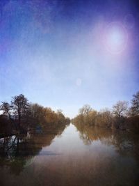 Reflection of trees in water against sky