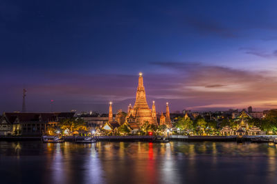 Illuminated buildings in temple against sky