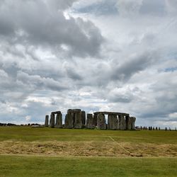 Built structure on field against cloudy sky