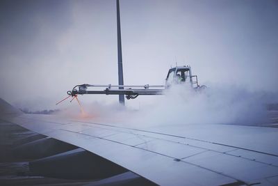 De-icing of airplane against cloudy sky