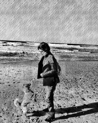 Woman standing on beach against sky