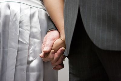 Midsection of couple holding hands