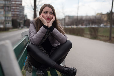 Portrait of young woman sitting outdoors