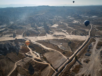 Aerial view of hot air balloon over landscape against sky