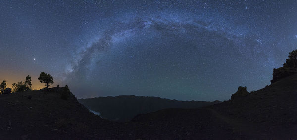 Low angle view of silhouette mountain against sky at night