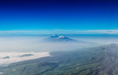 Aerial view of landscape against blue sky