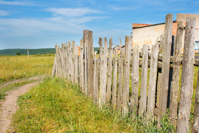 Panoramic view of wooden fence on field against sky