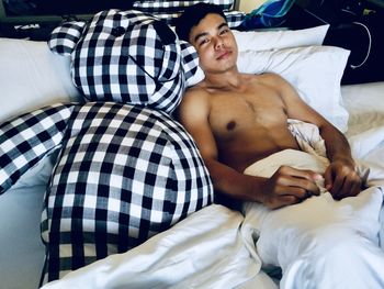 Young man lying on bed