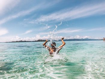 Man surfing in sea against sky