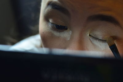 Close-up of woman applying eyeshadow