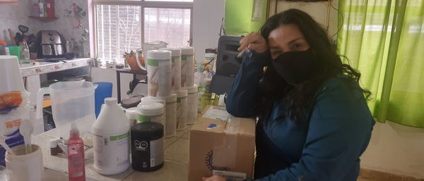 Young woman using phone while standing at home