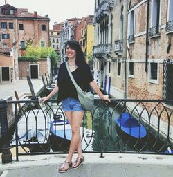 Portrait of young woman against buildings in city