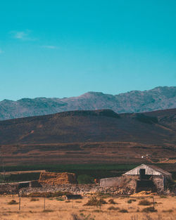 Scenic view of landscape and mountains against blue sky