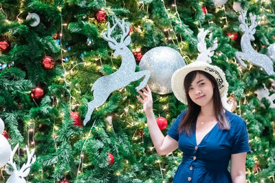 Full length of woman standing by tree
