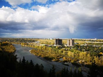 Scenic view of river by buildings in city against sky