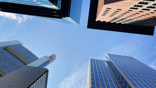 Low angle view of modern buildings against blue sky