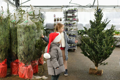 Children choose a christmas tree in a shop