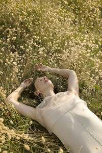 Woman lying among harestail grass 