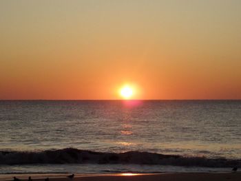 Scenic view of sea against orange sky