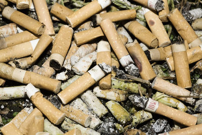 High angle view of cigarette butts on field