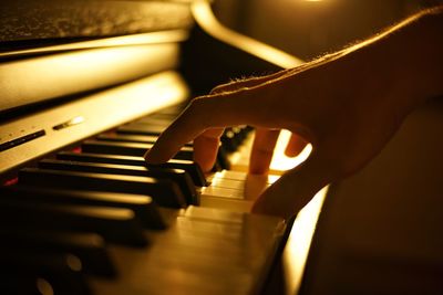 Cropped hand of man playing piano