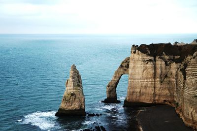 Scenic view of rock formation in sea against sky