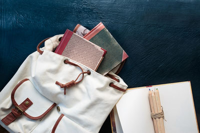 Close-up high angle view of bag with books on table