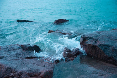 High angle view of waves splashing on rocks